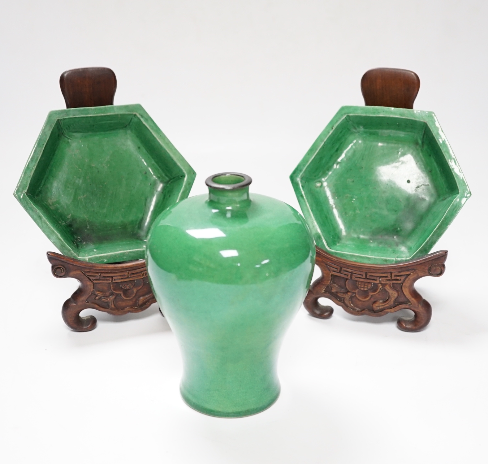 A Chinese green crackle glaze Meiping, late 19th/early 20th century and a pair of Kangxi green glazed hexagonal dishes with hardwood stands, stands 17cm high